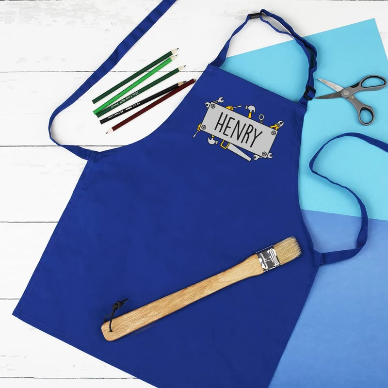 Blaue Werkenschürze für Kinder mit Handwerkermotiv und Namensaufdruck