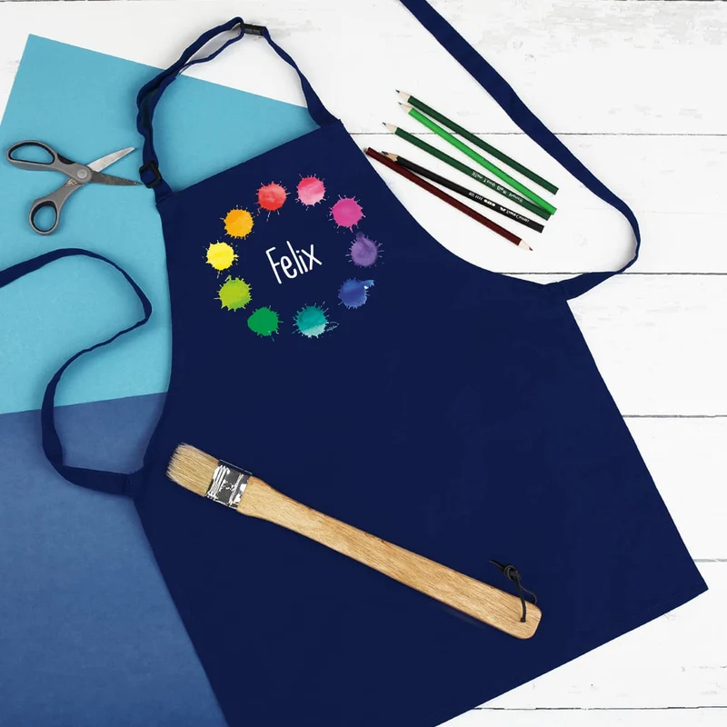 Dunkelblaue Kinderschürze mit Namensaufdruck und Farbklecks-Motiv